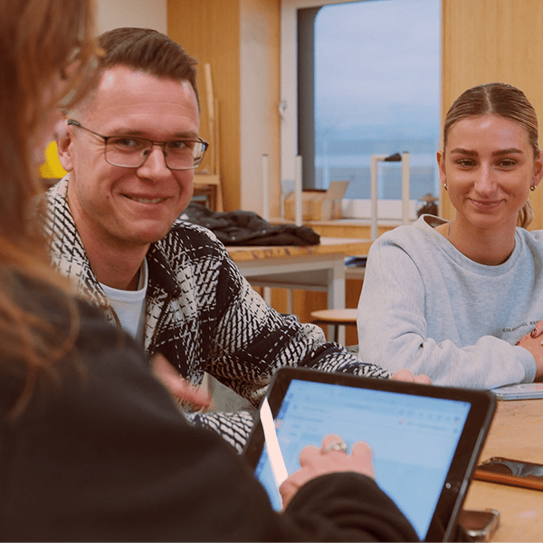 Team van de Kinderkoepel in vergadering met tablet. 2 vrouwen en 1 man bespreken project in ene lokaal.